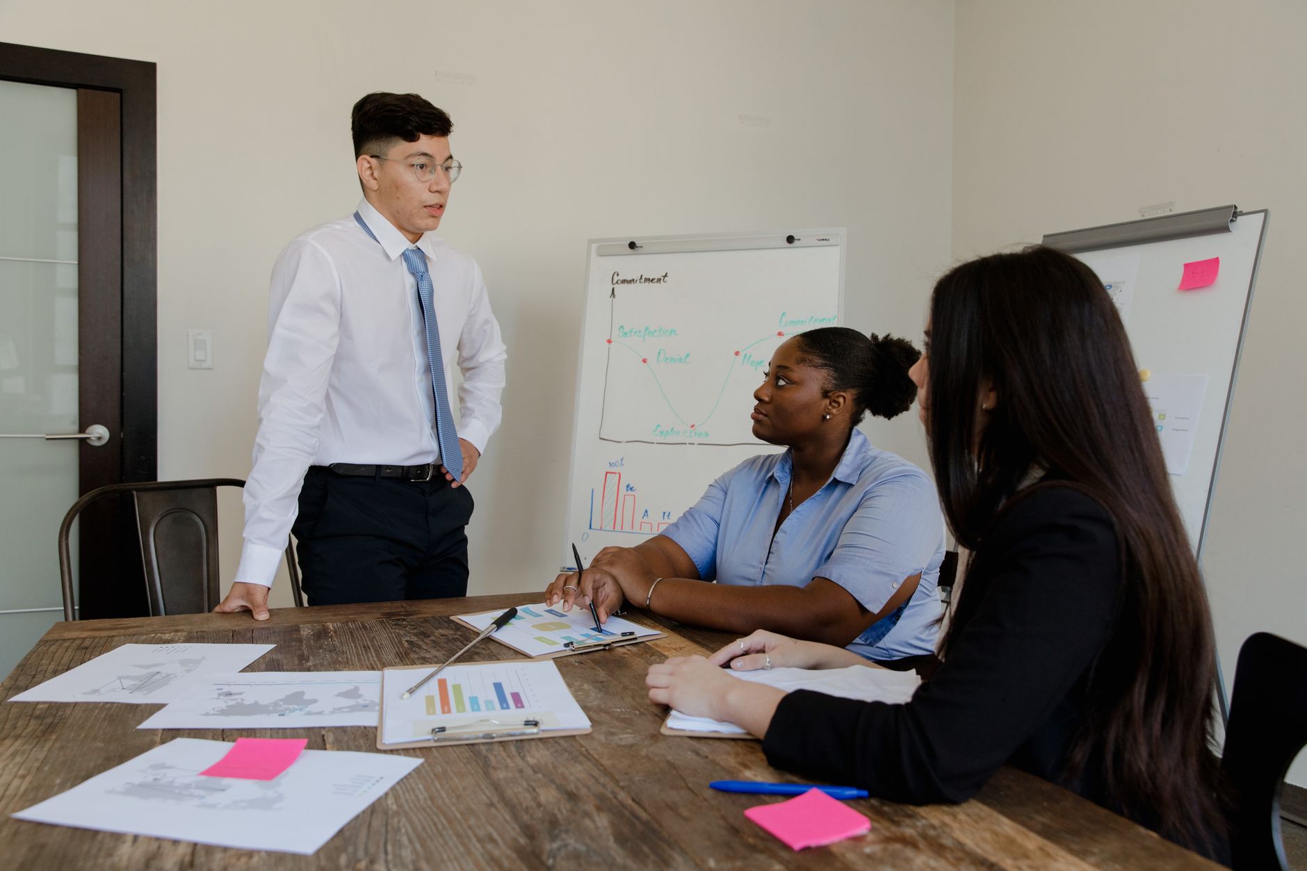 Confident business leaders discussing strategy around a conference table, showcasing teamwork and vision.