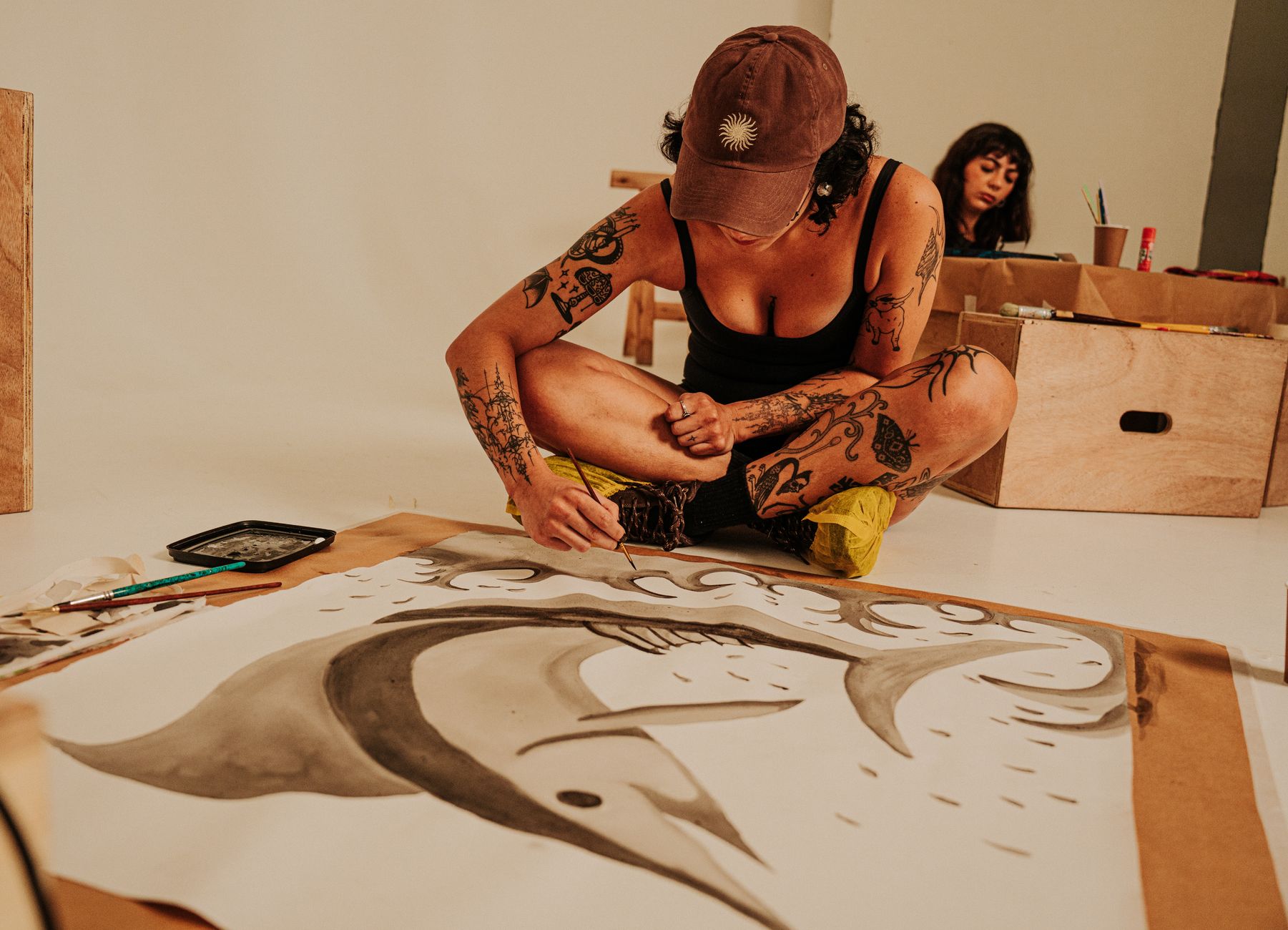A diverse group of artists painting, sculpting, and designing together in a bright studio, showcasing creative collaboration.