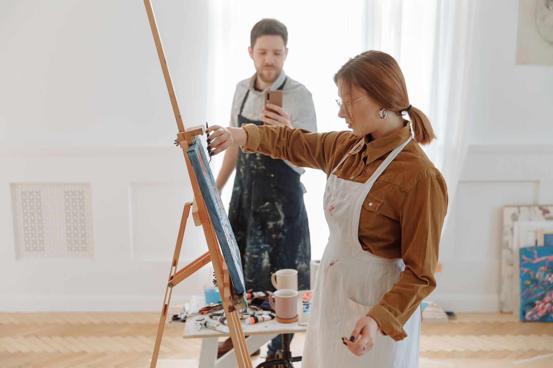 A group of diverse artists collaborating on vibrant murals in a lively studio